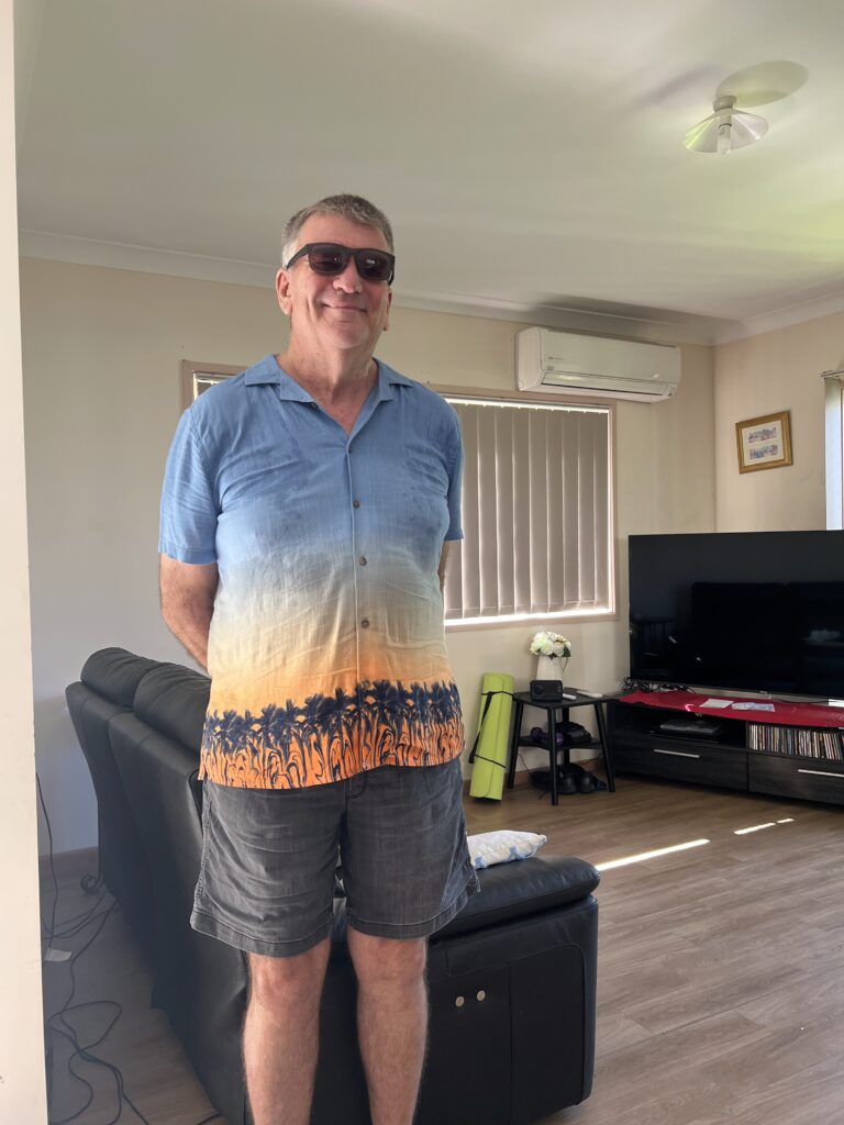 Joe confidently standing in the loungeroom of his home, proud of his space and the independence he maintains with support from Care to Change.