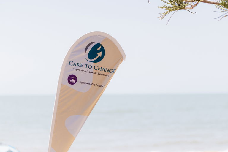 Care to Change branded teardrop banner flag beside the beach at an outdoor event