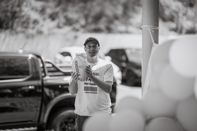 Black and white photo of a participant speaking into a microphone at a Care to Change community event