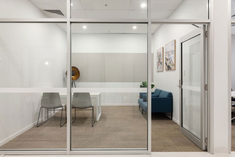Glass-walled private office with a desk and chairs at the Morayfield Hub