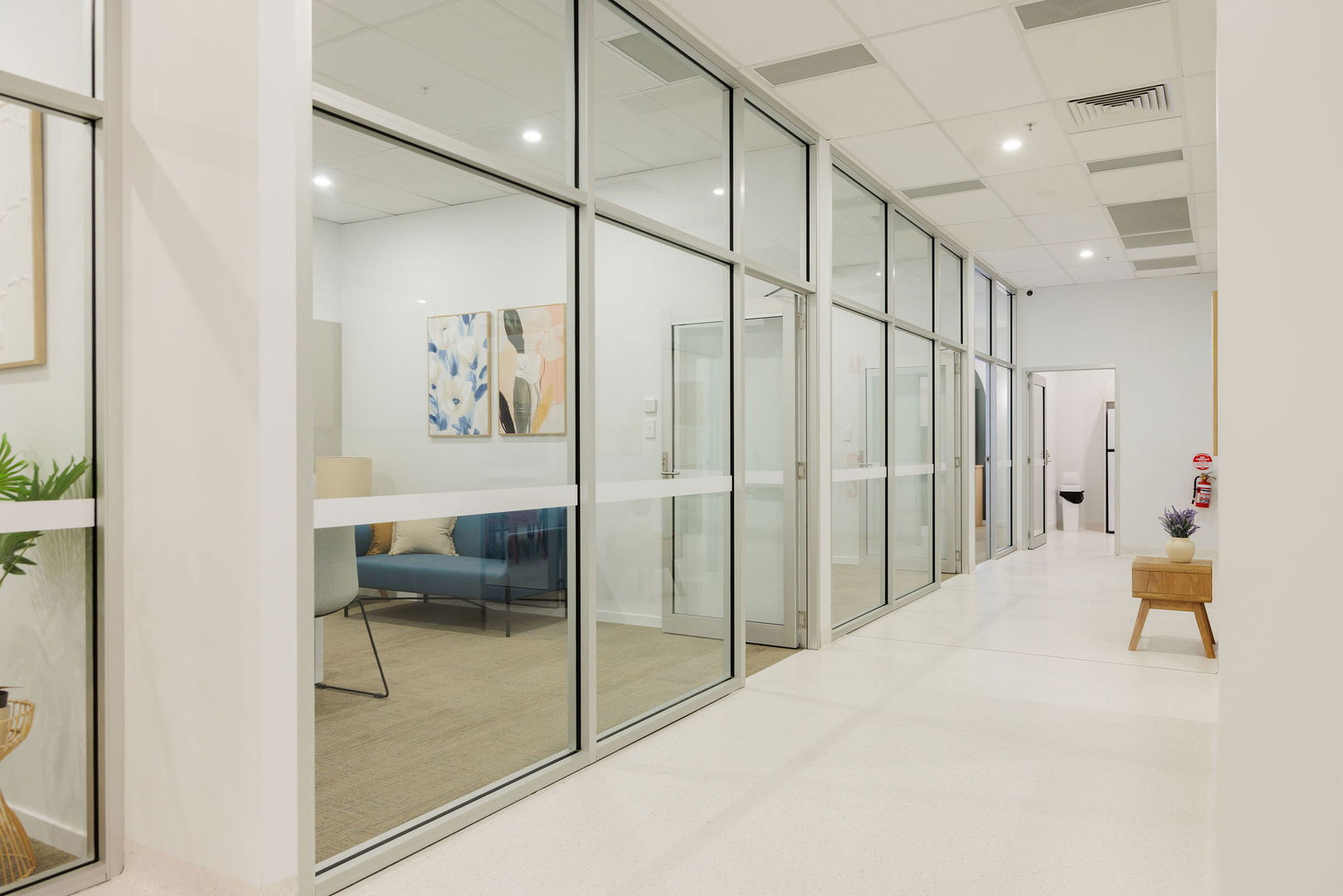Glass-walled office with a meeting table and seating at the Morayfield Hub