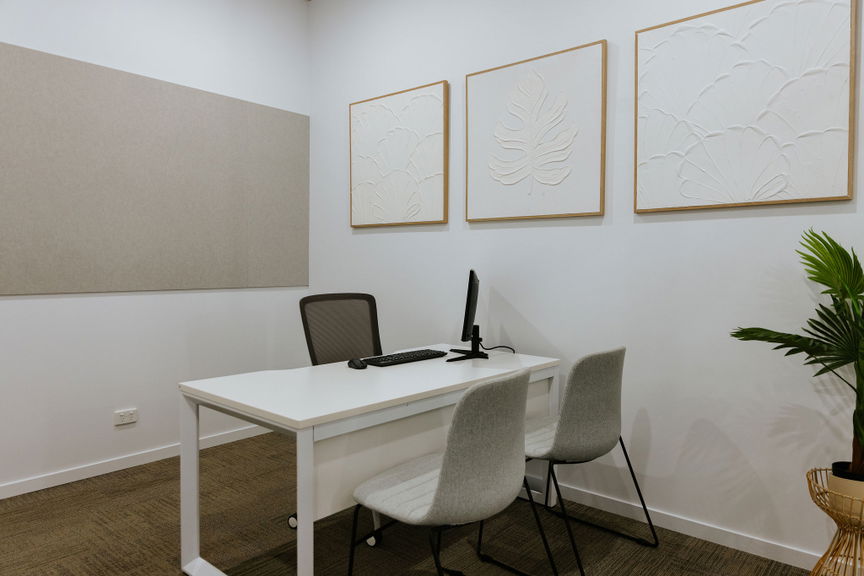 Private office furnished with a desk, monitor and two visitor chairs at the Morayfield Hub