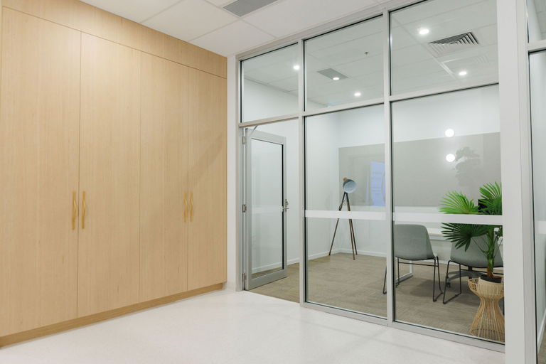 Private office with timber cabinetry and glass walls at the Morayfield Hub