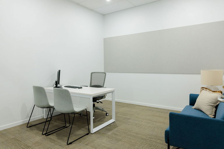 Fully equipped private office with a desk, monitor, chairs and a couch at the Morayfield Hub