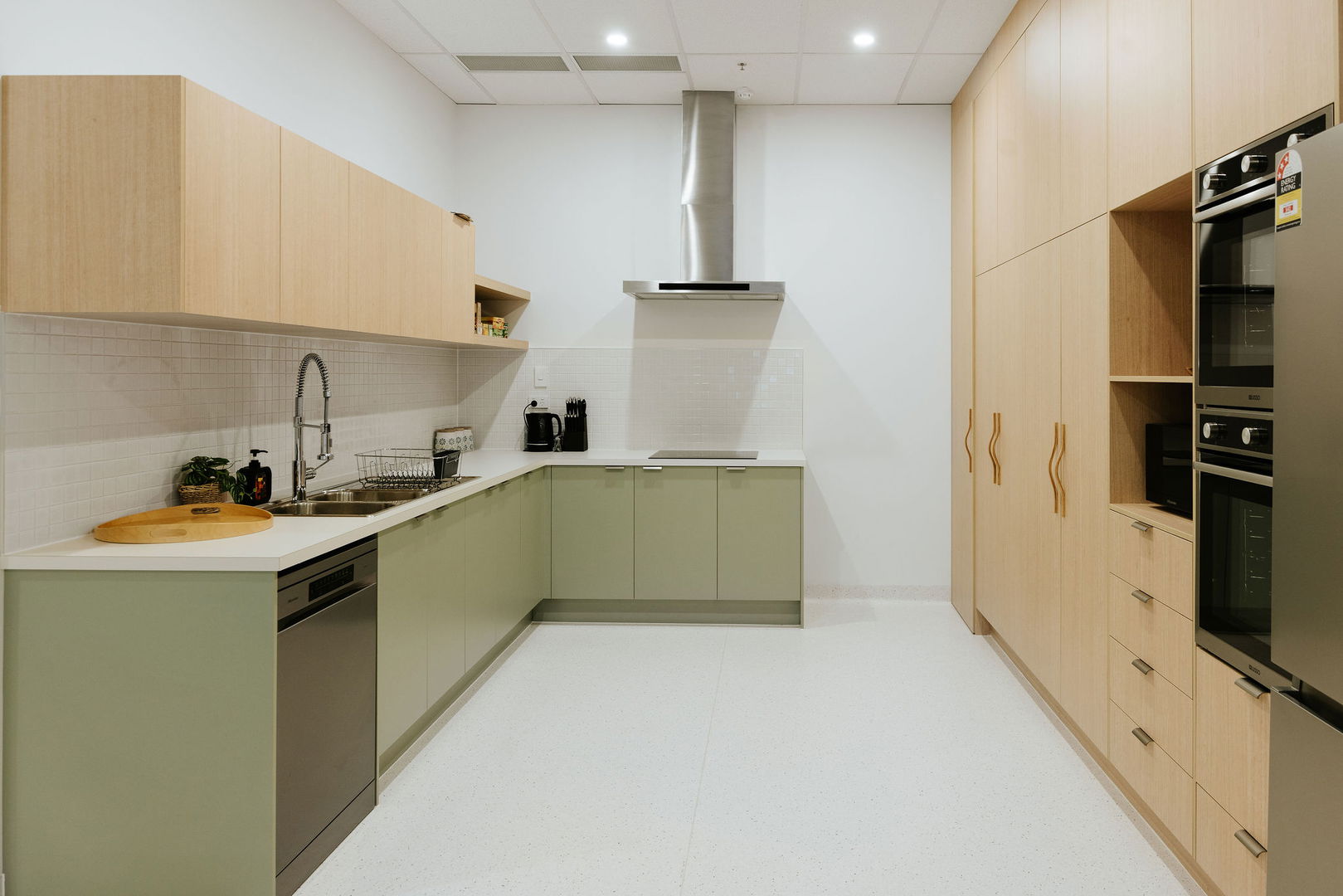 Fully equipped kitchen with sage cabinetry, oven and rangehood at the Morayfield Hub