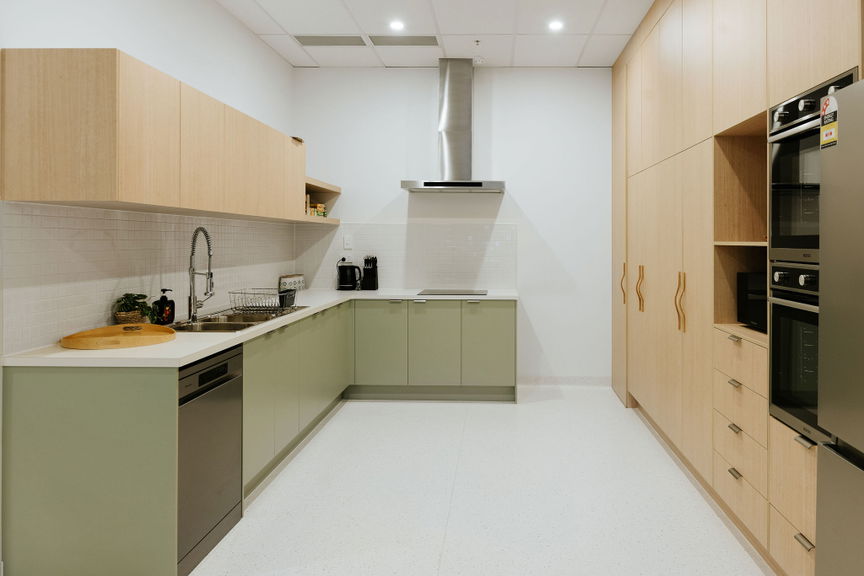 Fully equipped kitchen with sage cabinetry, oven and rangehood at the Morayfield Hub