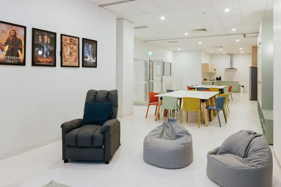 Open lounge and activity space with bean bag seating and framed artwork at the Morayfield Hub