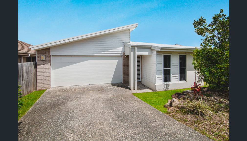 Front of the single-storey brick Care to Change supported home in Pimpama, with a covered entry and front lawn