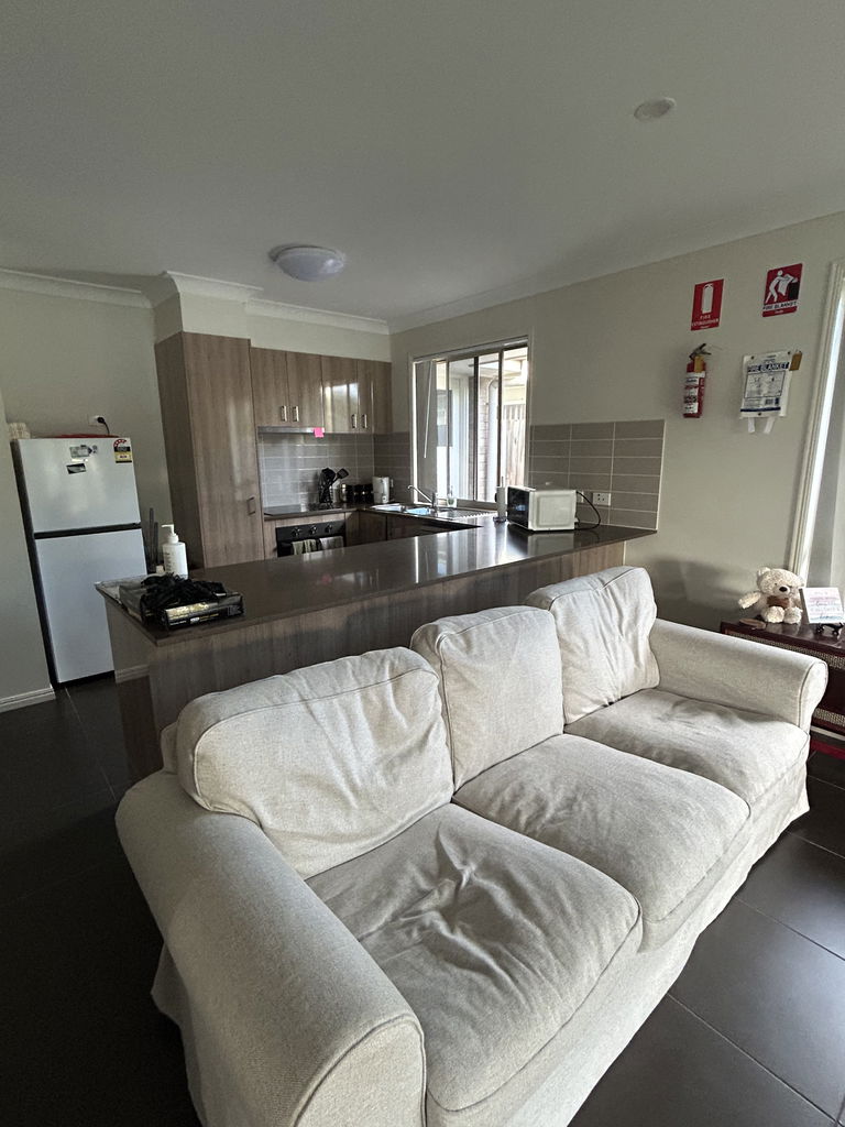 Open-plan kitchen and living area with a breakfast bar in the Care to Change supported home in Pimpama