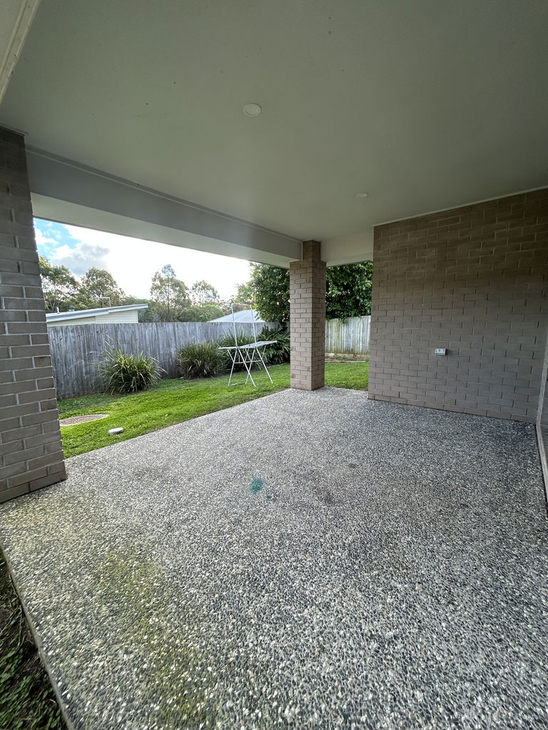 Covered outdoor area looking onto the fenced back lawn of the Care to Change supported home in Pimpama